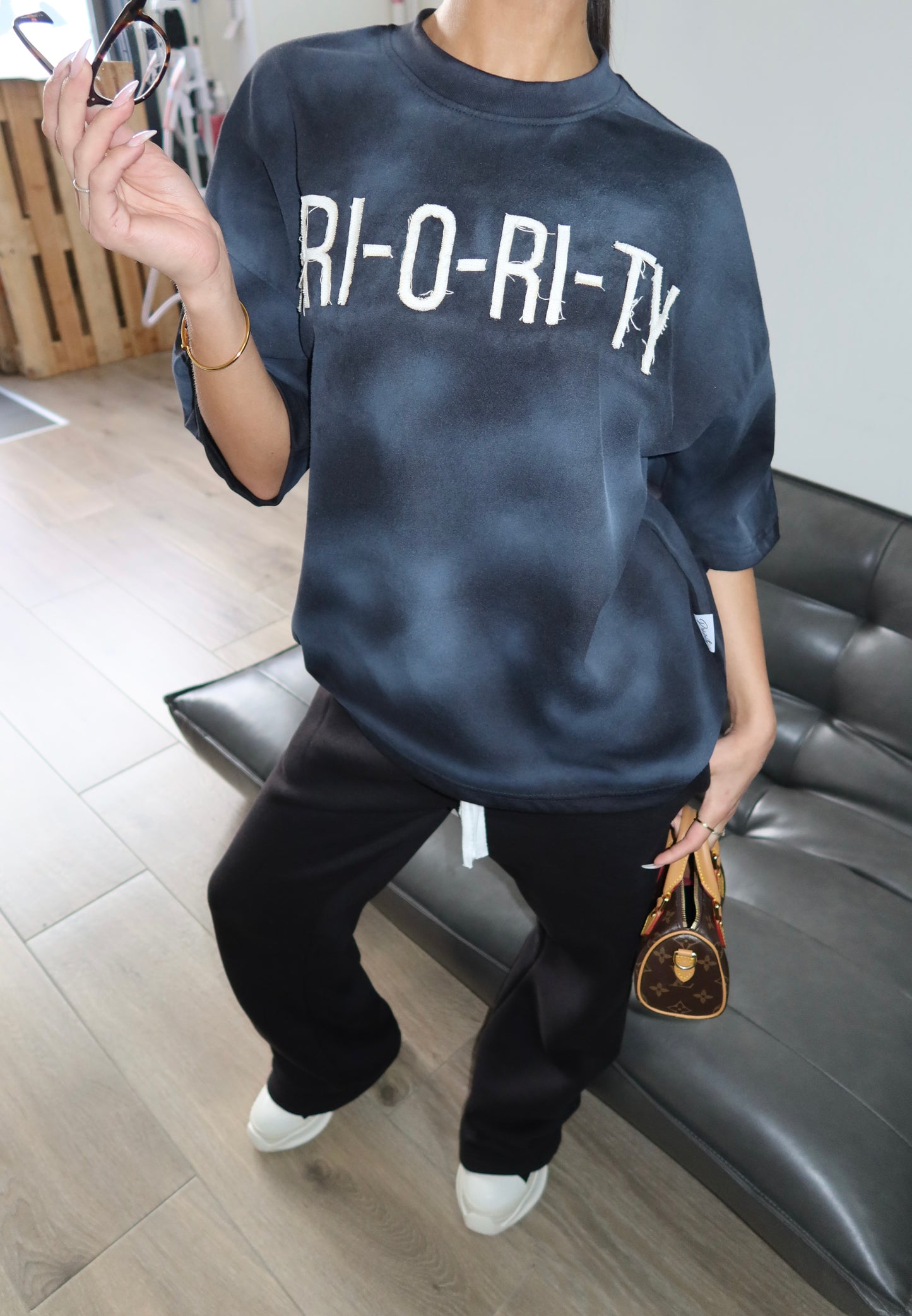 Priority: PRI-O-RI-TY tee SS25 – Zwart (Washed Black)