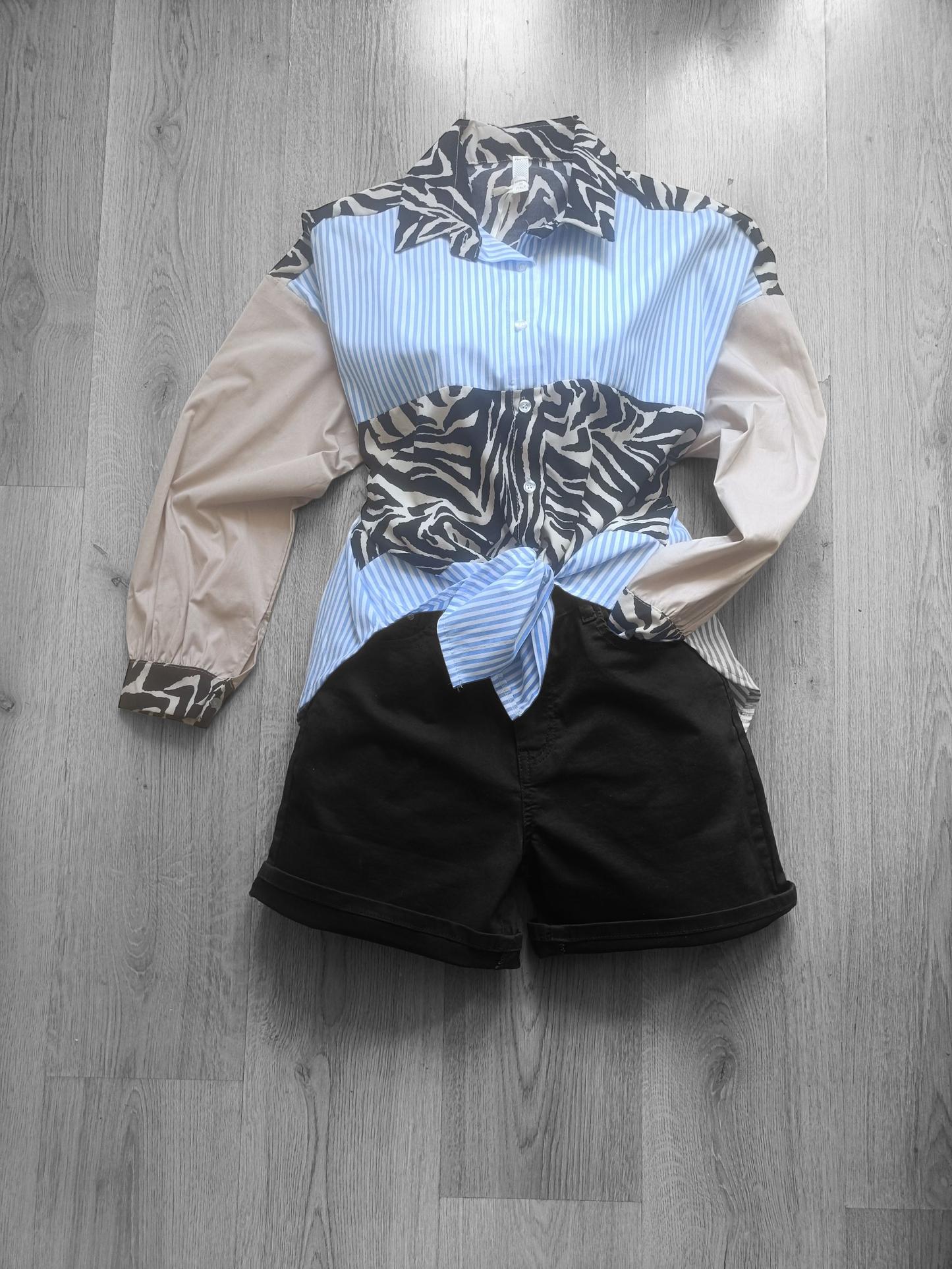 Zwarte BBS Jeans Shorts voor dames (zonder het sjaaltje) en blauw gestreepte blouse met zebraprint.