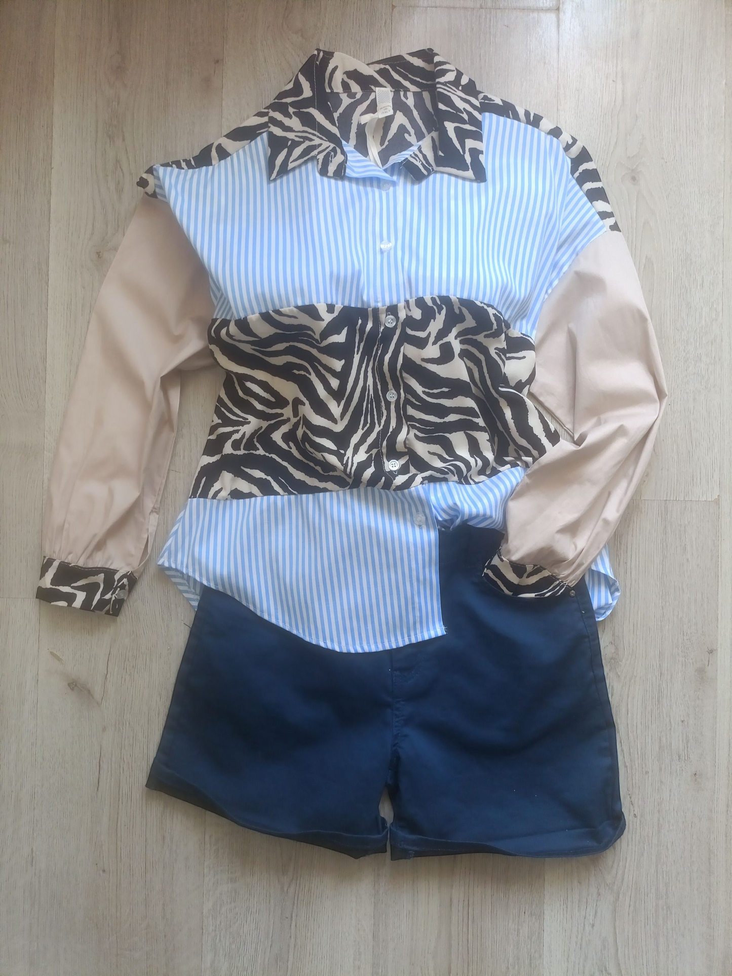 Donkerblauwe BBS Jeans Shorts voor dames (zonder het sjaaltje) en blauw gestreepte blouse met zebraprint.
