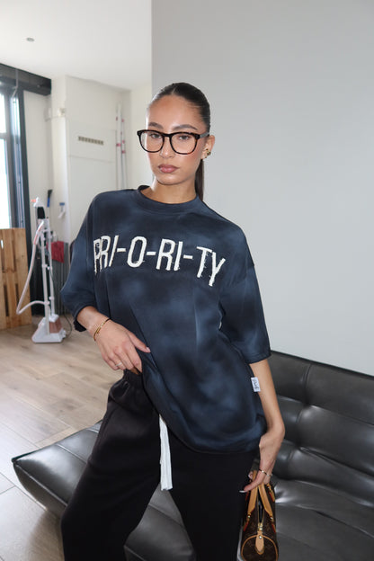 Priority: PRI-O-RI-TY tee SS25 – Zwart (Washed Black)