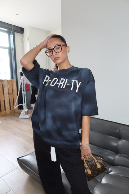 Priority: PRI-O-RI-TY tee SS25 – Zwart (Washed Black)