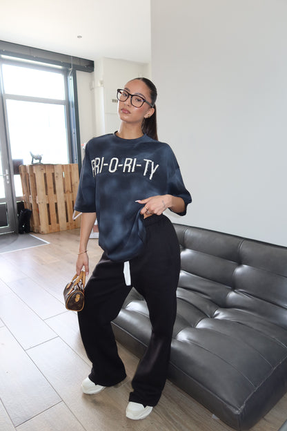 Priority: PRI-O-RI-TY tee SS25 – Zwart (Washed Black)