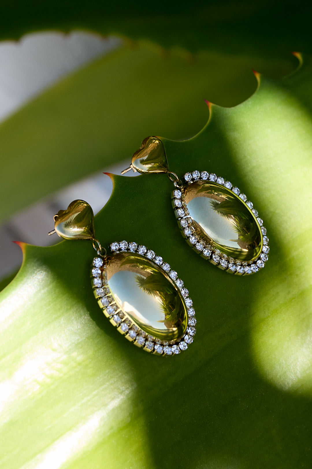 Statement oorbellen met ovale charm omringd met steentjes